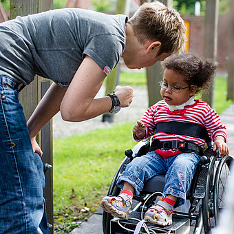 Kind im Rollstuhl mit Betreuer